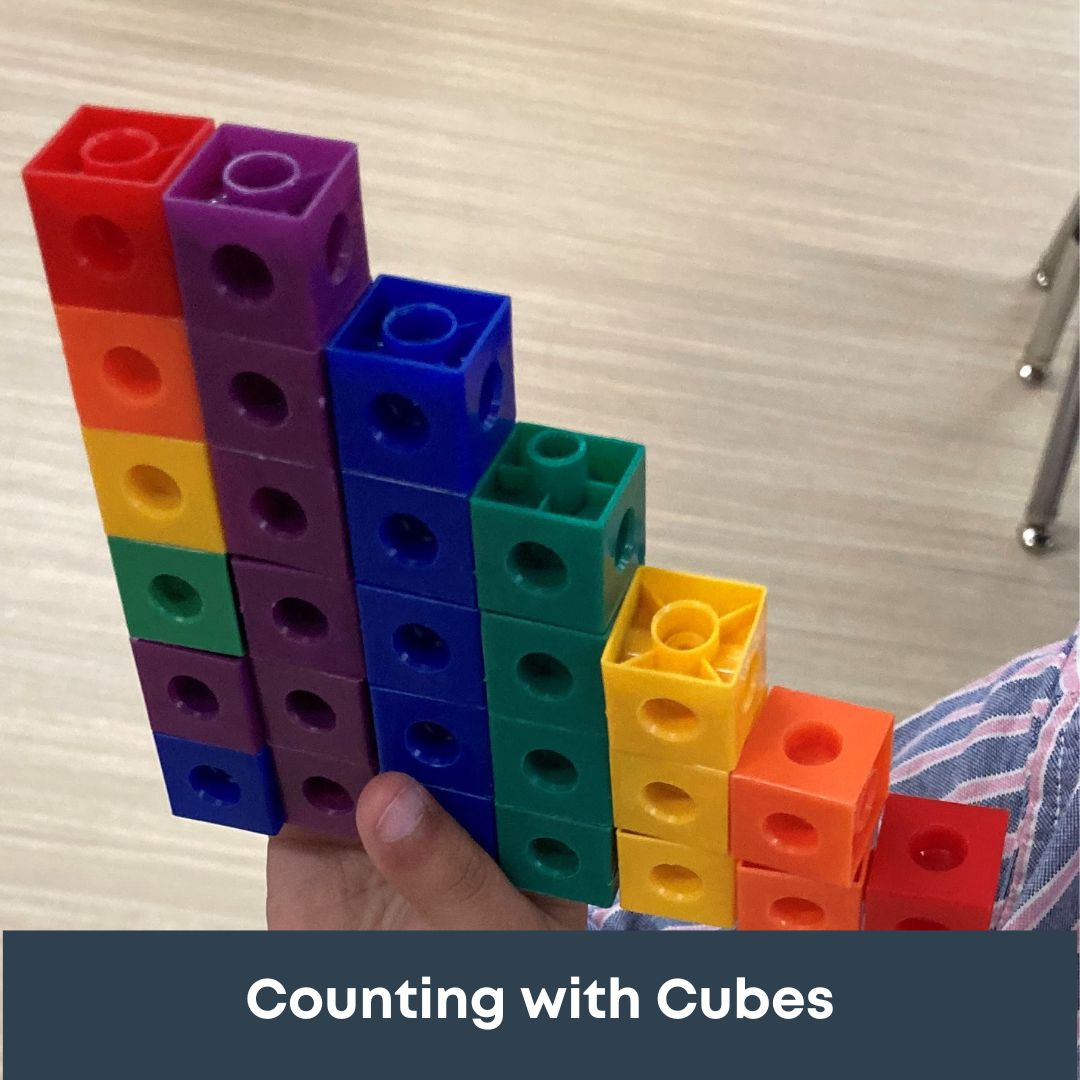 Children learning through play using a buddha board and cube linking blocks.
