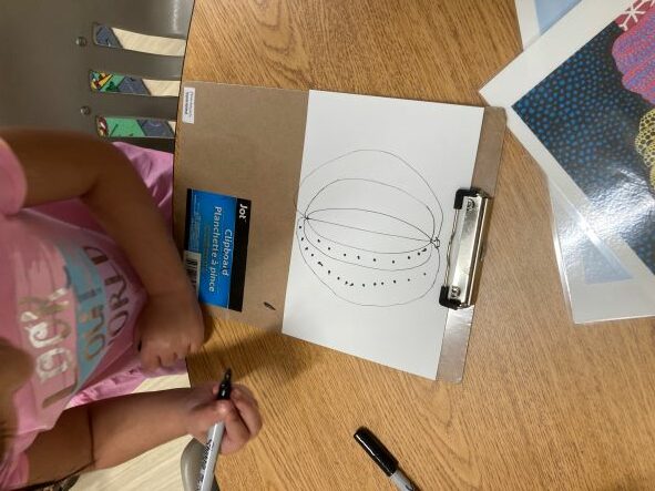 child creating pumpkin drawing